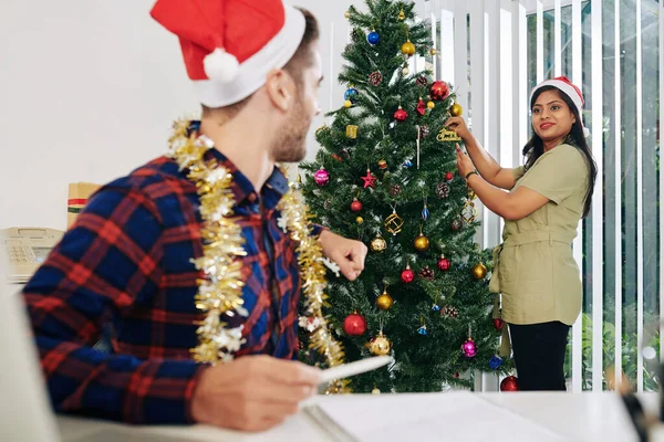 Güzel Gülümseyen Hintli Kadını Meslektaşına Ofisteki Noel Ağacını Nasıl Süsleyeceğini — Stok fotoğraf
