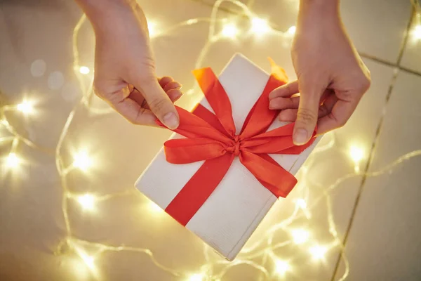 Tangan Wanita Muda Membuka Hadiah Natal Lampu Bercahaya Latar Belakang — Stok Foto