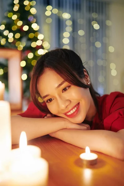 年轻多愁善感的漂亮亚洲女人看着圣诞前夜点燃蜡烛 — 图库照片
