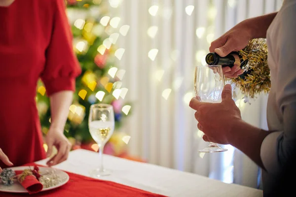 Muž Nalévání Šampaňské Flétně Když Jeho Žena Zdobí Vánoční Jídelní — Stock fotografie