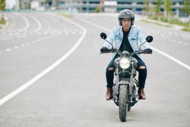 Otobanda sürat yaparken kask takan kendinden emin Vietnamlı motosikletçi.