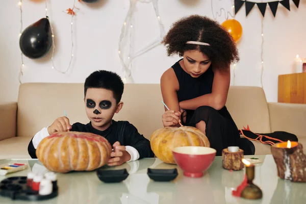 Adolescente Concentrada Hermano Menor Decorando Calabazas Talladas Para Celebración Halloween —  Fotos de Stock