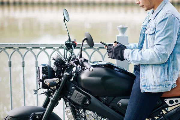 Imagem Recortada Motociclista Sério Sentado Bicicleta Verificando Mensagens Texto Smartphone — Fotografia de Stock