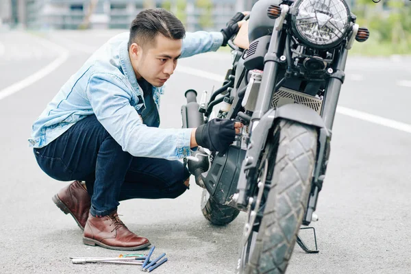 Seriöser Asiate Inspiziert Motorrad Und Sucht Nach Bruch — Stockfoto