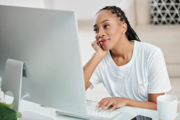微笑着年轻美丽的黑人女人在电脑屏幕上看爱情电影 — 图库照片