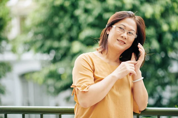 Ώριμη Βιετναμέζα Γυναίκα Γυαλιά Στέκεται Εξωτερικούς Χώρους Και Μιλάει Στο — Φωτογραφία Αρχείου