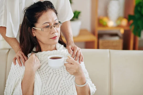 Seniorin Gibt Tasse Tee Und Warme Decke Ihren Traurig Nachdenklichen — Stockfoto