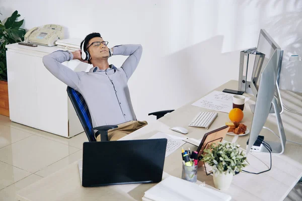 Zufriedener Lächelnder Indischer Programmierer Mit Kopfhörern Lehnt Sich Nach Beendigung — Stockfoto