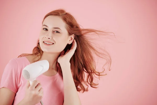 Porträtt Leende Söt Ung Kvinna Blåser Sitt Hår Isolerad Rosa — Stockfoto