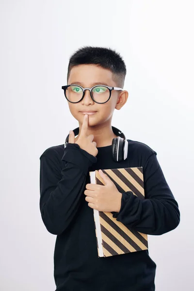 Niño Inquisitivo Pensativo Gafas Sosteniendo Libro Tocando Labio Aislado Blanco — Foto de Stock