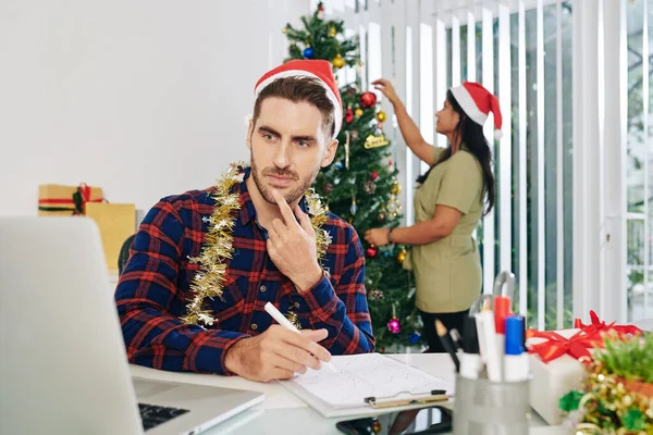 Pensive Young Businessman Santa Hat Working Annual Report His Colleague — Stock Photo, Image