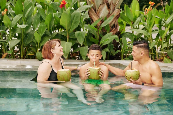 Família Feliz Três Pessoas Sentadas Piscina Bebendo Coquetéis Refrescantes Coco — Fotografia de Stock