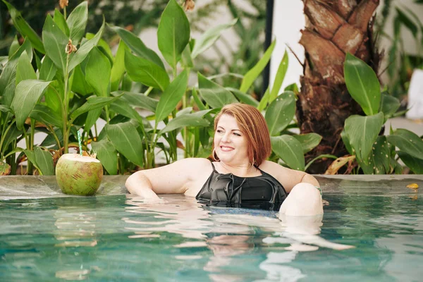 在宾馆游泳池和椰子鸡尾酒里笑个漂亮的女人放松一下 — 图库照片