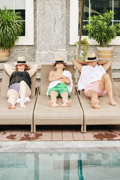 スパリゾートのプールで泳いだ後 親と息子はシャイラウンジで寝ています — ストック写真