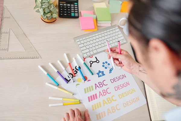 会社のロゴを作成する際に様々なカラフルなフェルトチップペンを使用するデザイナー — ストック写真