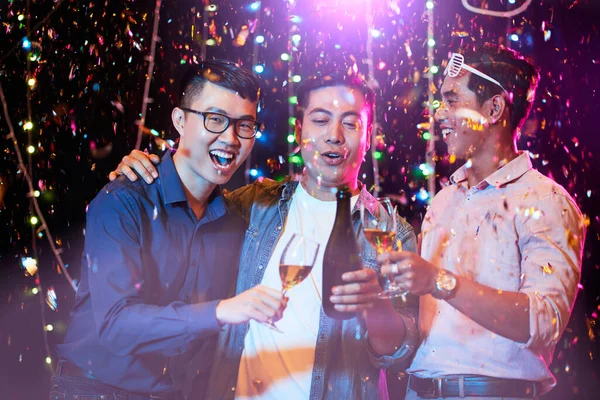 Vrolijke Knuffelen Mannelijke Vrienden Drinken Champagne Onder Vallen Confetti Bij — Stockfoto