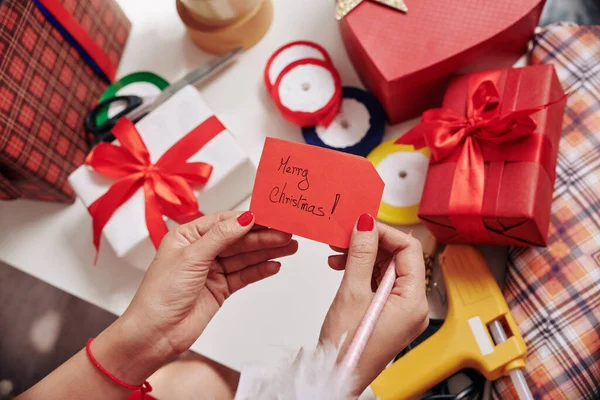 Tangan Wanita Memegang Catatan Merry Christmas Dia Menyiapkan Untuk Dibungkus — Stok Foto
