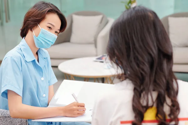 Positieve Medische Verpleegkundige Beschermend Masker Gesprek Met Vrouwelijke Patiënt Vuldocument — Stockfoto