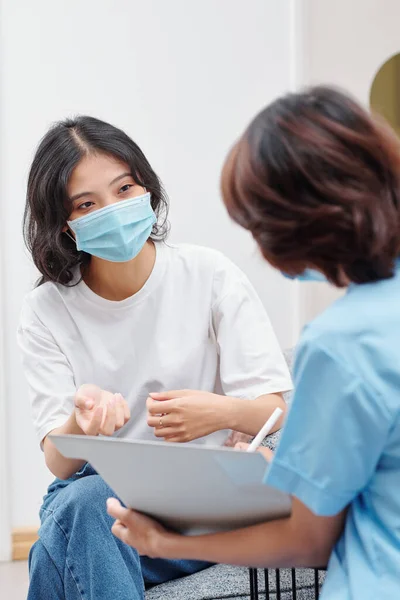 Tıbbi Maskeli Genç Vietnamlı Kadın Dişçi Kliniğindeki Hemşireyle Konuşuyor — Stok fotoğraf