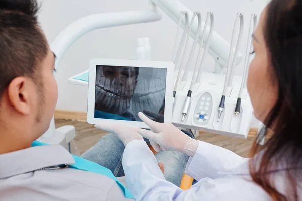 Ortodonta Pokazujący Pacjentowi Prześwietlenie Szczęki Mówiący Które Zęby Należy Leczyć — Zdjęcie stockowe