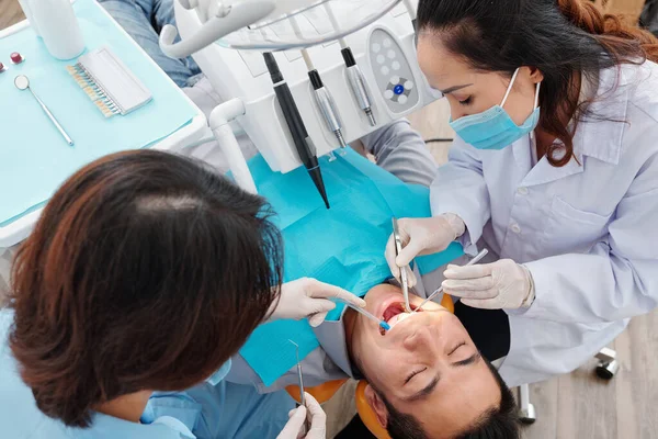 Dentista Máscara Médica Tratando Dentes Paciente Com Ajuda Assistente Vista — Fotografia de Stock