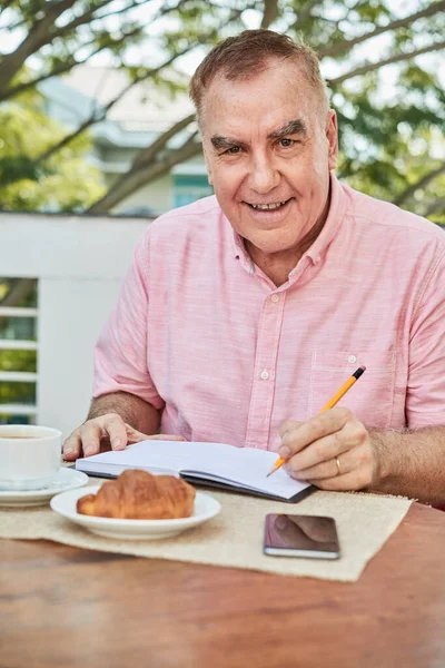 Portrét Šťastného Muže Věku Jíst Croissant Kávou Snídani Dělat Poznámky — Stock fotografie