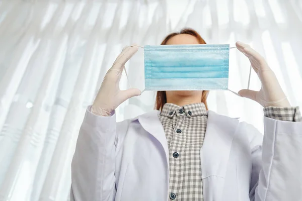 Kvinna Läkare Sätta Skyddsmask Innan Patienten Undersökning Underifrån — Stockfoto