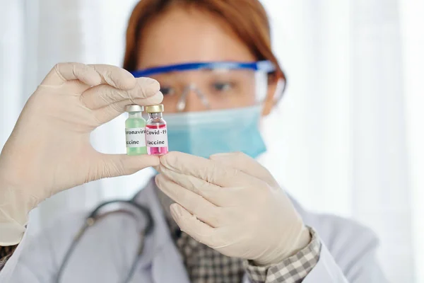 Serious Female Physician Looking Two Vials Green Pink Vaccines Covid — Stock Photo, Image