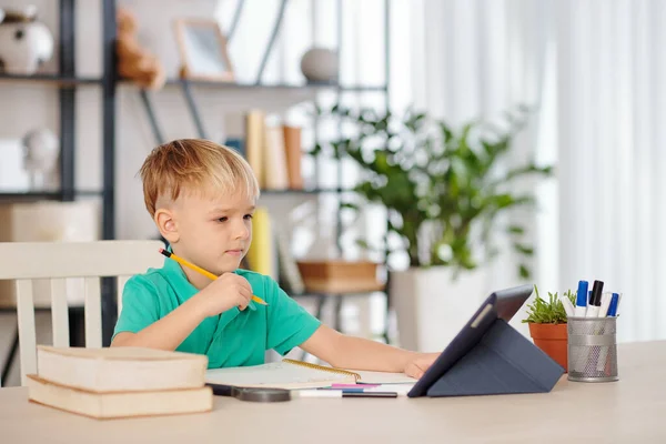 Slimme Kleine Jongen Zitten Aan Het Bureau Kijken Naar Onderwijs — Stockfoto