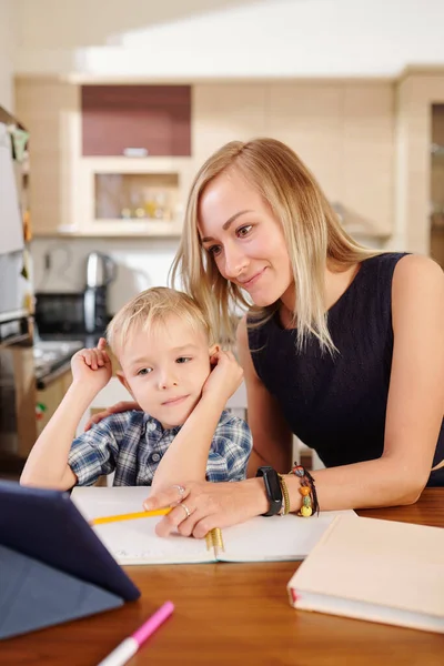 Smiling Mother Pointing Tablet Computer Explaining Lesson Her Child Who — Stock Photo, Image