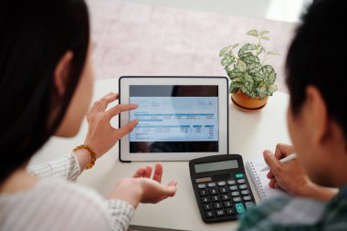 Genç evli çift elektrik enerjisi tüketimi ve faturaları ödeyerek grafiği tartışıyor