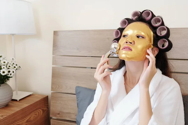 Schöne Asiatin Massiert Ihr Gesicht Mit Goldener Silikonmaske Nachdem Sie — Stockfoto