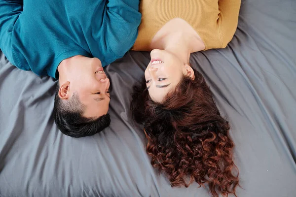 Neşeli Genç Asyalı Çift Evde Yatakta Uzanıyor Birbirlerine Yukarıdan Bakıyorlar — Stok fotoğraf