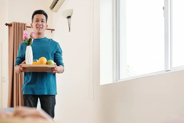 Fürsorglicher Junger Asiatischer Mann Bringt Tablett Mit Valentinstagsfrühstück Und Blumen — Stockfoto