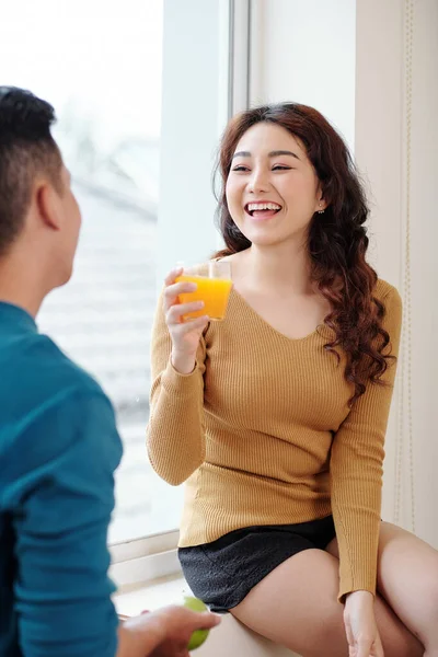 Riéndose Joven Asiática Bebiendo Jugo Naranja Cuando Habla Con Novio —  Fotos de Stock