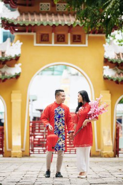 Genç Vietnamlı çift yeni yılda tapınağa giderken el ele tutuşuyorlar.