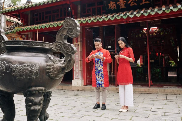 身穿传统服装的越南年轻夫妇手握烟棍在佛教庙里祈祷 — 图库照片