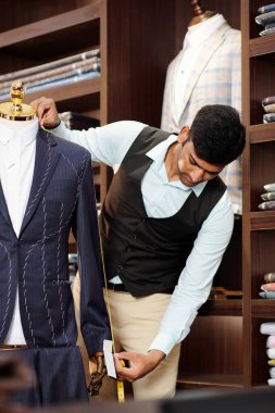 Özel dikim ceketin kol uzunluğunu ölçen profesyonel bir terzi. 
