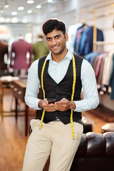 Retrato Sorrindo Bonito Jovem Alfaiate Indiano Usando Aplicativo Smartphone Quando — Fotografia de Stock