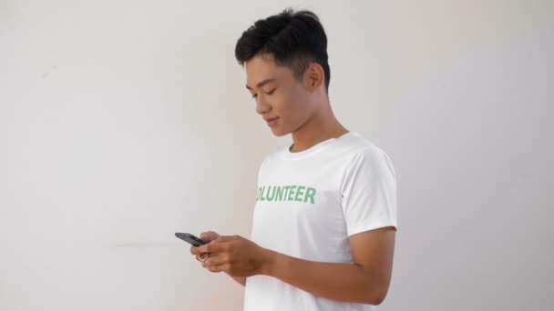 Blocco Del Volontario Asiatico Maschio Utilizzando Smartphone Poi Guardando Fotocamera — Video Stock
