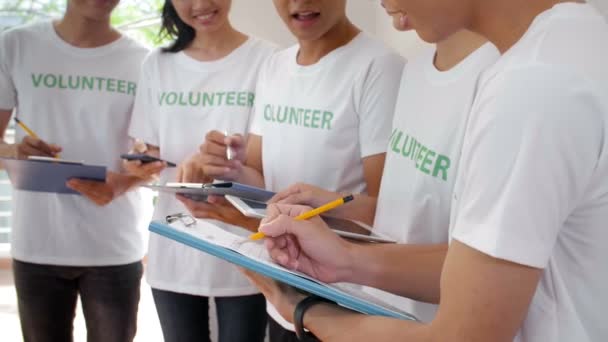 Közepes Felvétel Önkéntesek Terveiről Miközben Csapattársuk Jegyzetel Írótáblával Ceruzával — Stock videók