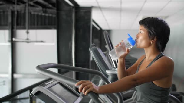 禁止亚洲女运动员穿着运动服站在跑步机上喝水 — 图库视频影像