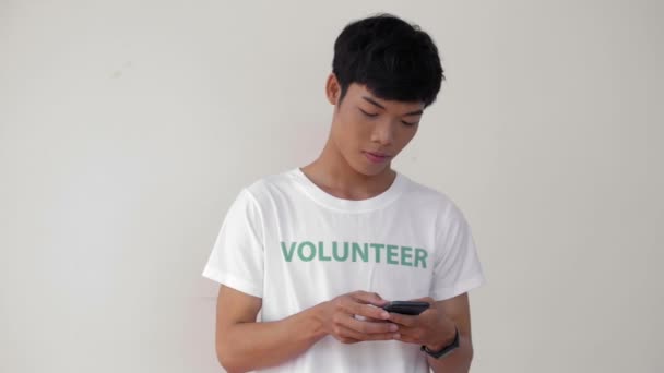 Spåra Rätt Ung Asiatisk Man Volontär Uniform Meddelanden Med Vän — Stockvideo
