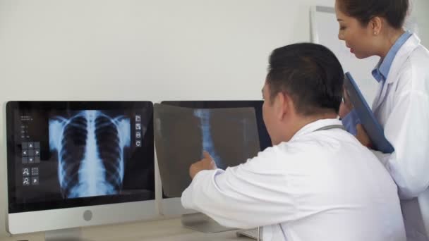 Rear View Male Asian Doctor Sitting Desk Looking Computer Screen — Stock Video