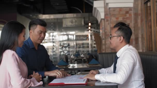 Aflåsning Tre Asiatiske Forretningspartnere Sidder Restaurant Underskrive Kontrakt Derefter Ryste – Stock-video