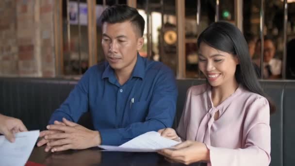Średnie Ujęcie Azjatyckiego Biznesmena Dającego Kopie Kontraktu Mężczyźnie Kobiecie Siedzącym — Wideo stockowe