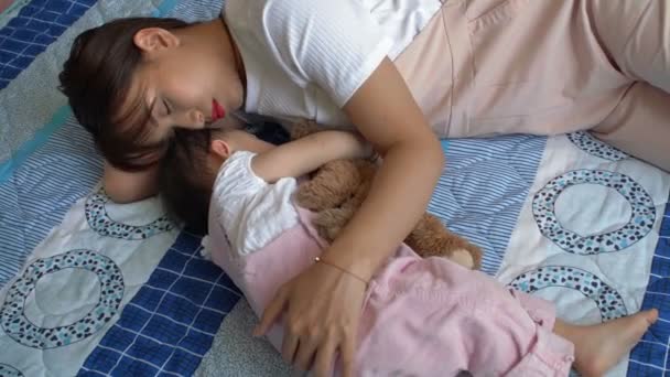 母親が近くに横たわって彼女をパッチしている間 小さなアジアの子供が眠っているの高い角度のビュー — ストック動画