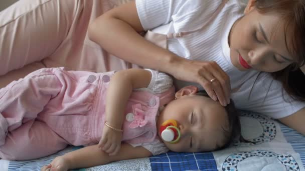 Śledzenie Prawa Małej Azjatki Śpiącej Podczas Gdy Jej Matka Leży — Wideo stockowe