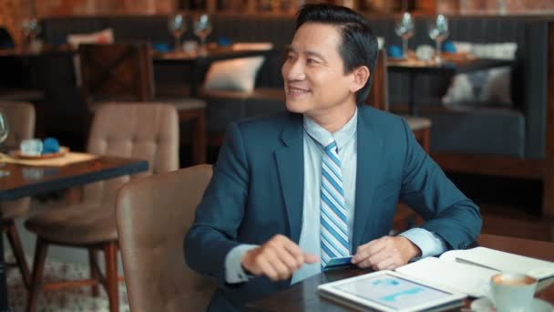 Fröhlicher Asiatischer Unternehmer Mittleren Alters Der Vom Café Aus Arbeitet — Stockvideo