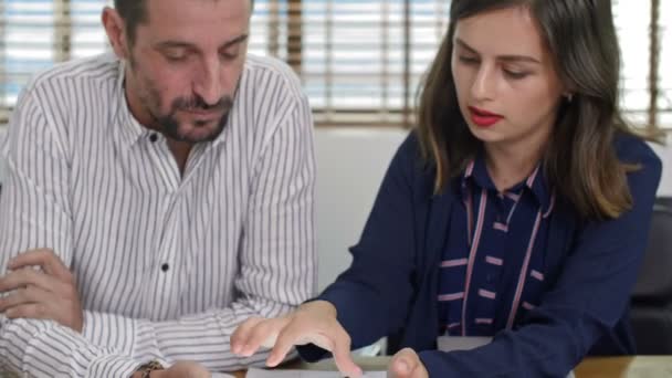 사업가와 사업가가 책상에 태블릿으로 무엇인가를 그것에 이야기하는 모습을 십시오 — 비디오